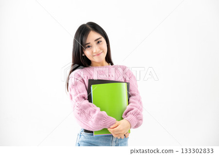 年輕女子手持筆記本和文件站在那裡 年輕女子手持筆記本和文件站在那裡 133302833