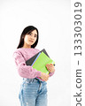 年輕女子手持筆記本和文件站在那裡 133303019