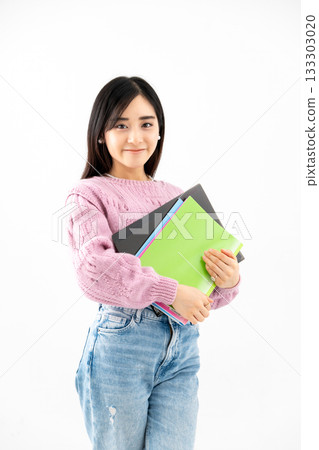 年輕女子手持筆記本和文件站在那裡 年輕女子手持筆記本和文件站在那裡 133303020