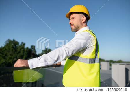 Engineer posing near solar panels on rooftop outdoors Engineer posing near solar panels on rooftop outdoors 133304648