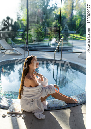 Long-haired young woman in white at the swimming pool in spa center 133304677