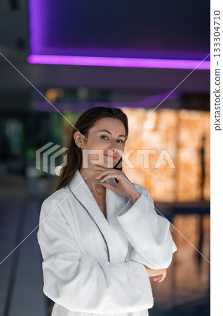 Long-haired pretty woman in white bath robe feeling relaxed 133304710