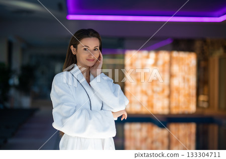 Long-haired pretty woman in white bath robe feeling relaxed 133304711