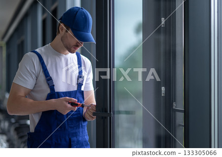 Craftsman installing hardware on glass door or partition 133305066