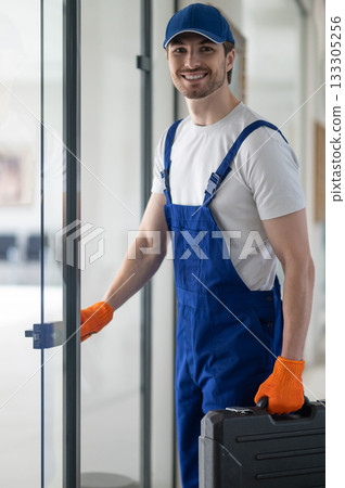 Man carrying black case standing in corridor Man carrying black case standing in corridor 133305256