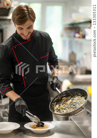 Chef cooking seafood or pasta with sauce in kitchen Chef cooking seafood or pasta with sauce in kitchen 133305311
