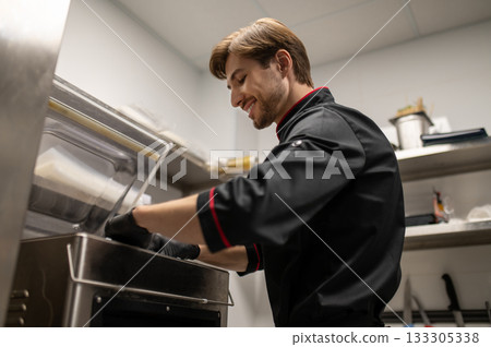 Cook working in restaurant kitchen preparing meals Cook working in restaurant kitchen preparing meals 133305338