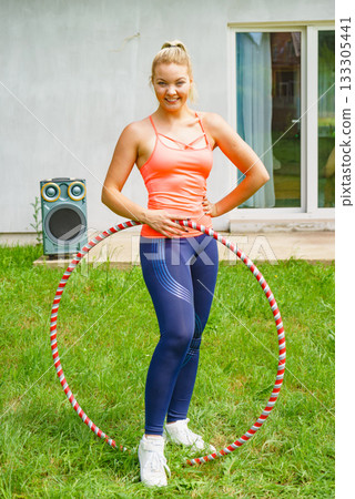 Young woman with hoola hoop outdoors 133305441