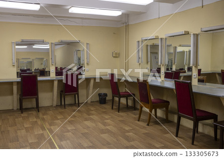 a dilapidated old dressing room in a theater with mirrors and chairs 133305673