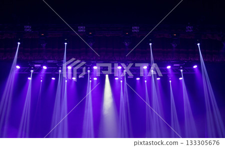 Multicolored beams of stage lighting illuminate the stage of the hall before the performance 133305676