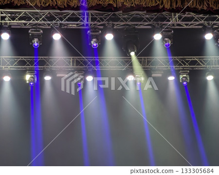 Multicolored beams of stage lighting illuminate the stage of the hall before the performance Multicolored beams of stage lighting illuminate the stage of the hall before the performance 133305684