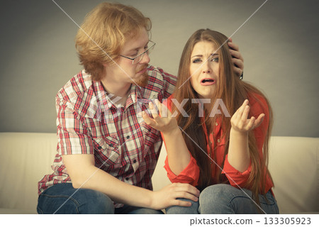 Woman confiding to man on sofa 133305923