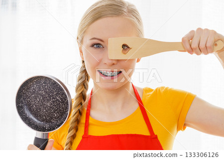 Woman holding cooking pan and spatula 133306126