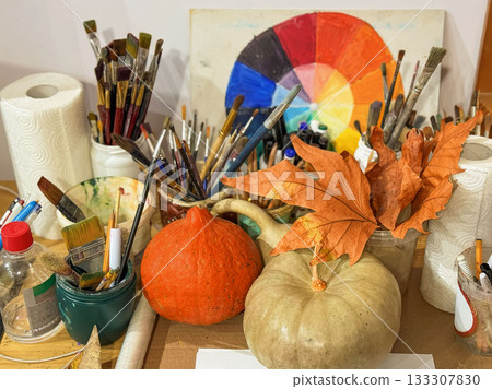 Thanksgiving-themed art studio with pumpkins, maple leaves, painting tools arranged in seasonal creative chaos. Concept of seasonal creativity, inspiration, artistic process, cozy autumn inspiration Thanksgiving-themed art studio with pumpkins, maple leaves, painting tools arranged in seasonal creative chaos. Concept of seasonal creativity, inspiration, artistic process, cozy autumn inspiration 133307830