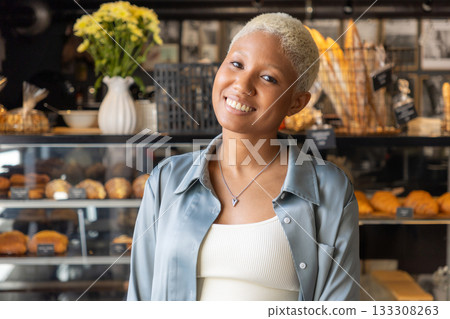 African American woman with short blond hair smiles and holds laptop in her hands. African American woman with short blond hair smiles and holds laptop in her hands. 133308263
