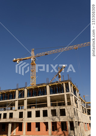 construction site with crane and building in background. yellow colored crane is in center of stage. construction site with crane and building in background. yellow colored crane is in center of stage. 133308309