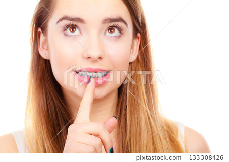 Woman smiling showing teeth with braces 133308426