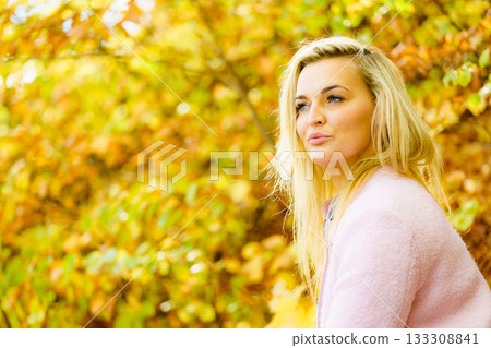 Blonde woman relaxing in autumn park Blonde woman relaxing in autumn park 133308841