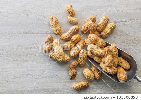 Peanuts in shell. Groundnuts in scoop on kitchen table. Top view. 133308858