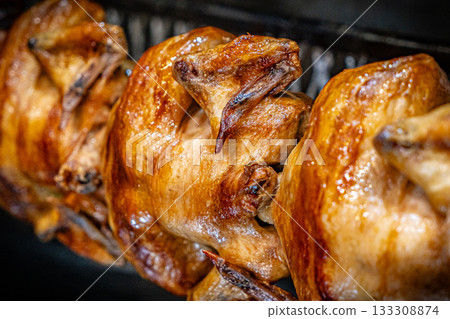 Barbecue roast Chicken in a row turning at industrial roaster grill 133308874