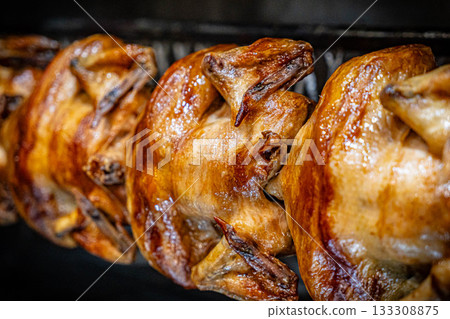 Barbecue roast Chicken in a row turning at industrial roaster grill 133308875