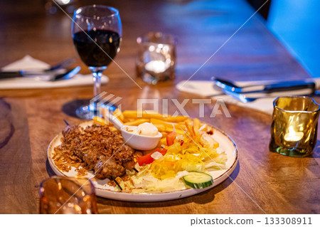 healthy barbecue. Chicken kebab with vegetables and herbs, salad and red wine and candles 133308911