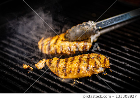 Delicious juicy meat steak cooking on grill. Kitchen tongs. Aged prime rare roast grilling tenderloin fresh marble tenderness beef. Prime beef fry on electric roaster, rosemary black pepper, salt. Delicious juicy meat steak cooking on grill. Kitchen tongs. Aged prime rare roast grilling tenderloin fresh marble tenderness beef. Prime beef fry on electric roaster, rosemary black pepper, salt. 133308927
