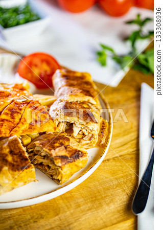 Chicken roll breast stuffed with butter, garlic and dill. Served with baked potato slices and fresh herbs. 133308936