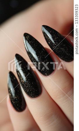 Elegant Black Glitter Nails Shine Brightly in a Close-Up View at a Beauty Salon 133309323