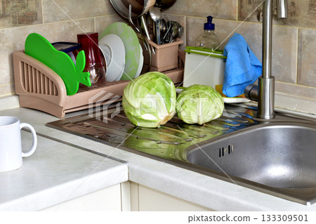 Heads of cabbage lie on the sink. 133309501