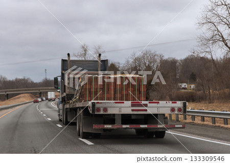 Heavy truck transporting wooden pallets on highway during cloudy weather Heavy truck transporting wooden pallets on highway during cloudy weather 133309546