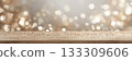 Wooden table with scattered glitter and soft champagne bokeh background 133309606