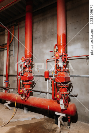 Fire sprinkler valves and red pipes in industrial plant, safety equipment, vertical view Fire sprinkler valves and red pipes in industrial plant, safety equipment, vertical view 133309673