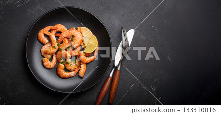 Cooked grilled shrimps lemon parsley black plate seafood appetizer black background copy space 133310016