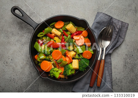 Stir fried colorful mixed vegetables cast iron skillet healthy cooking diet vegan 133310019