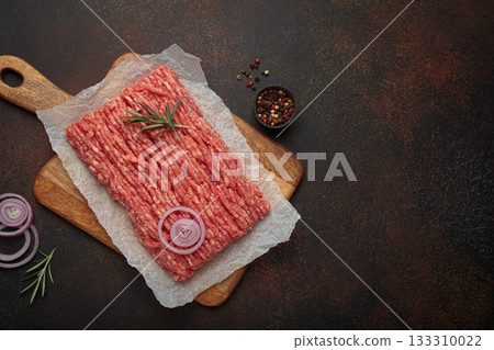 Raw ground minced meat chopping wooden board ingredients rosemary onion cooking copy space 133310022