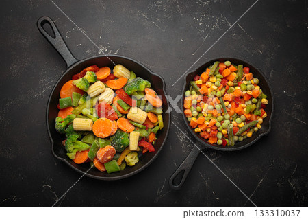 Frozen mixed vegetables two cast iron skillets black healthy cooking defrosting meal prep 133310037