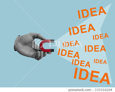 Hand with magnet attracts word idea showing creative thinking. 133310204