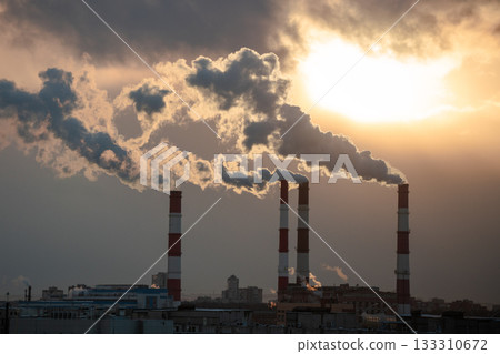 Smoke from factory pipe of heat station in city in winter. Fuel oil or natural gas-fired power plant 133310672