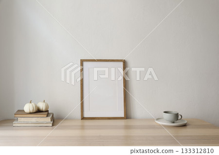 Elegant interior. Winter art composition. Blank vertical wooden picture frame poster mockup on table. Beige wall background. Cup of coffee, tea. White pumpkins, books. Thanksgiving, Christmas decor. 133312810