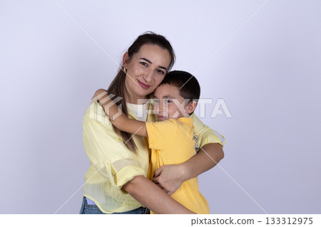 A woman and a child are embracing each other 133312975