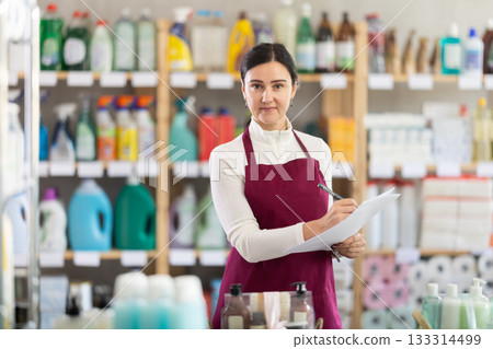 saleswoman writes down on paper the amount of the remaining goods in the warehouse saleswoman writes down on paper the amount of the remaining goods in the warehouse 133314499