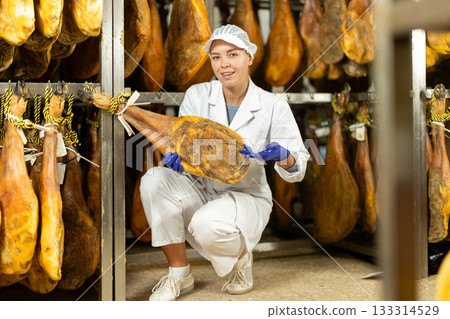 young specialist keeps a large jamon in the workshop 133314529