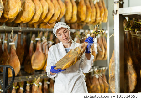 Girl employee checks jamon. Quality control 133314553