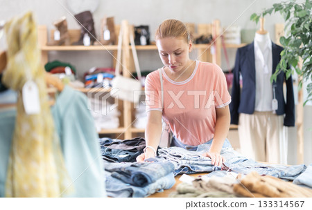 Teenage girl choosing pantaloons in clothing store 133314567