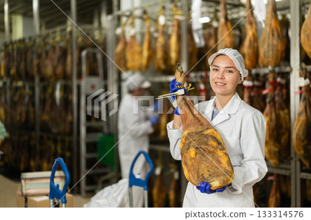 young specialist keeps a large jamon in the workshop 133314576