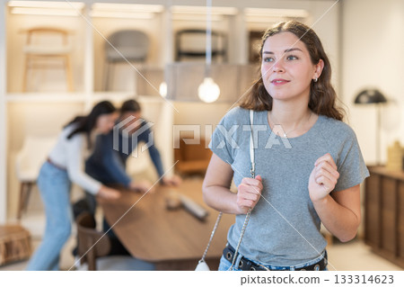 Woman buyer chooses furniture in furniture store Woman buyer chooses furniture in furniture store 133314623