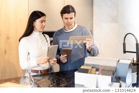 Couple chooses together the material from which they will order furniture and kitchen set 133314624