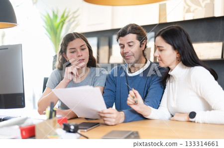 Married couple discusses the terms of purchasing a new kitchen set with furniture store manager Married couple discusses the terms of purchasing a new kitchen set with furniture store manager 133314661