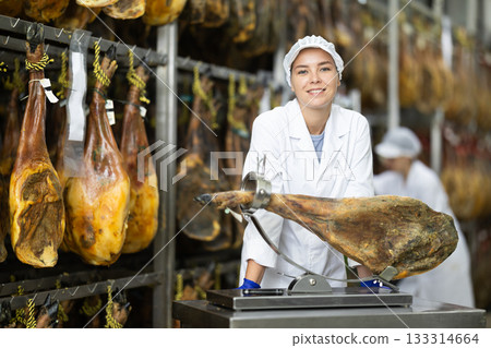 woman in a white coat presents high quality ham 133314664